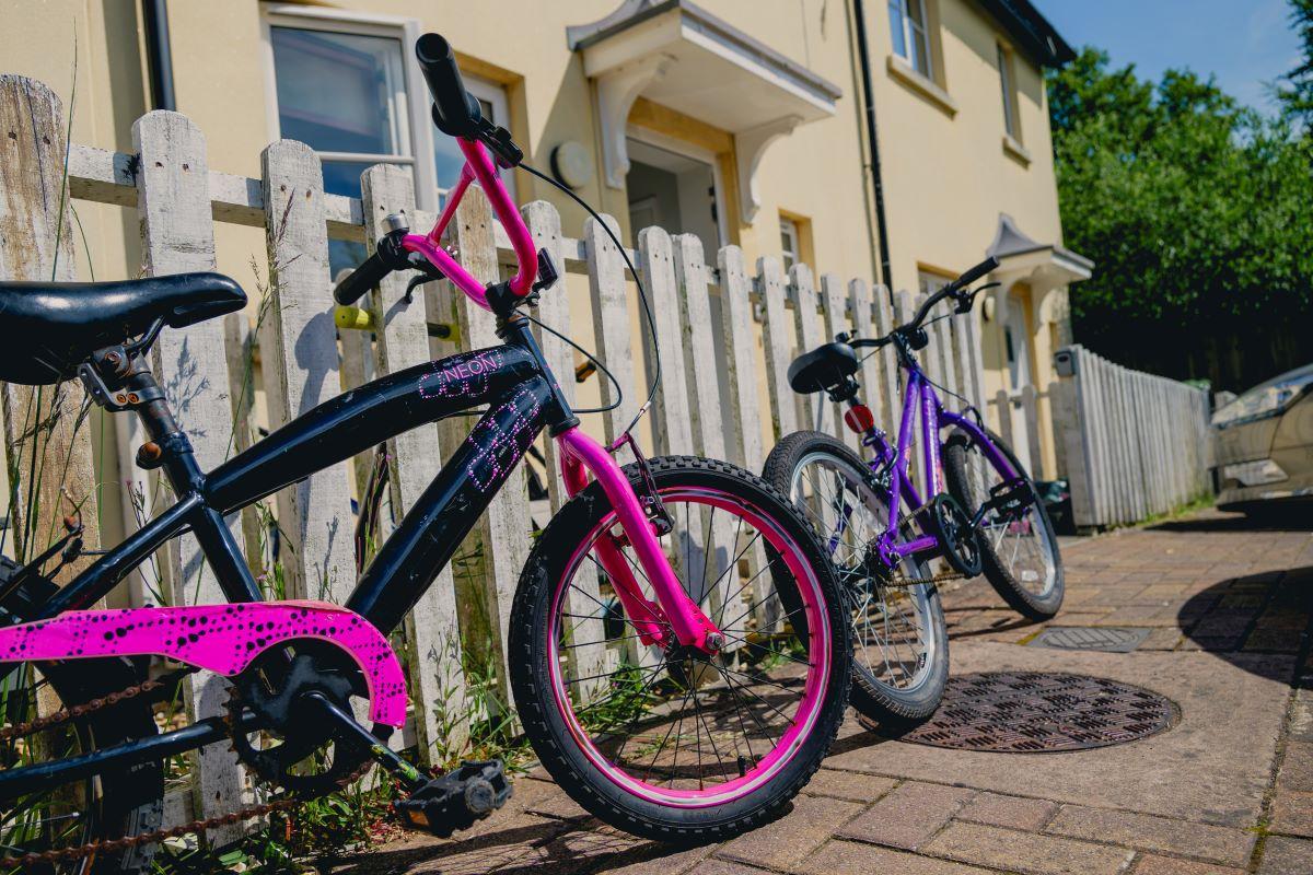This is an image of children's bikes up against a fence outside of affordable housing in Dorset