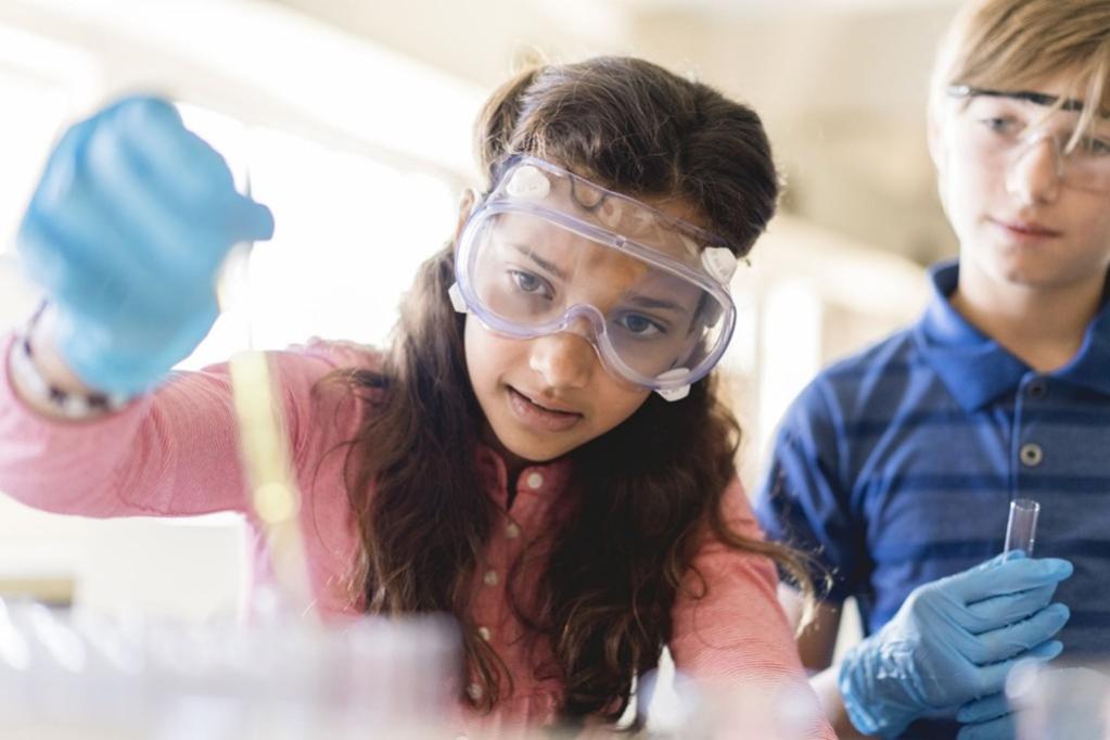 This shows a pupil carrying out a chemistry experiment in the classroom