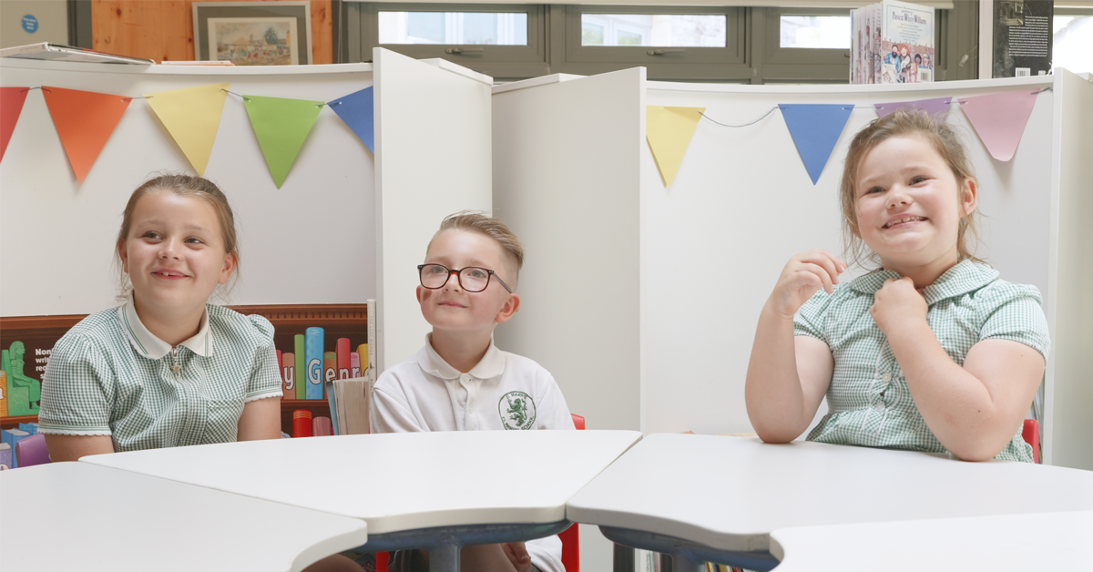 Three children sat at desk