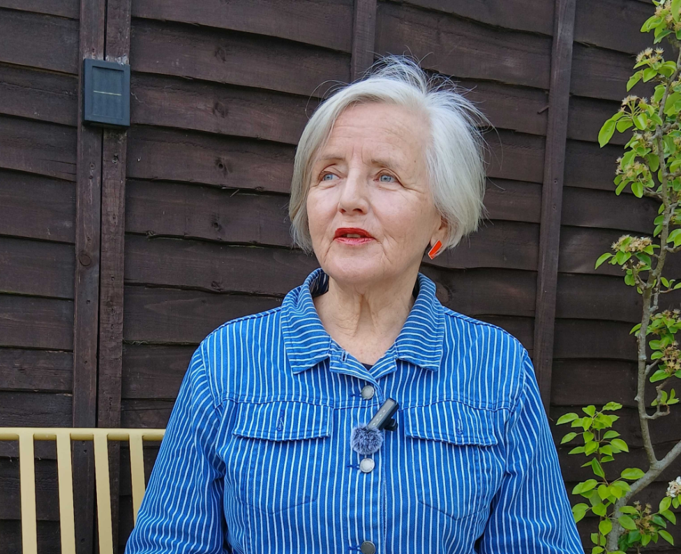 This is an image of Ros sitting in her garden