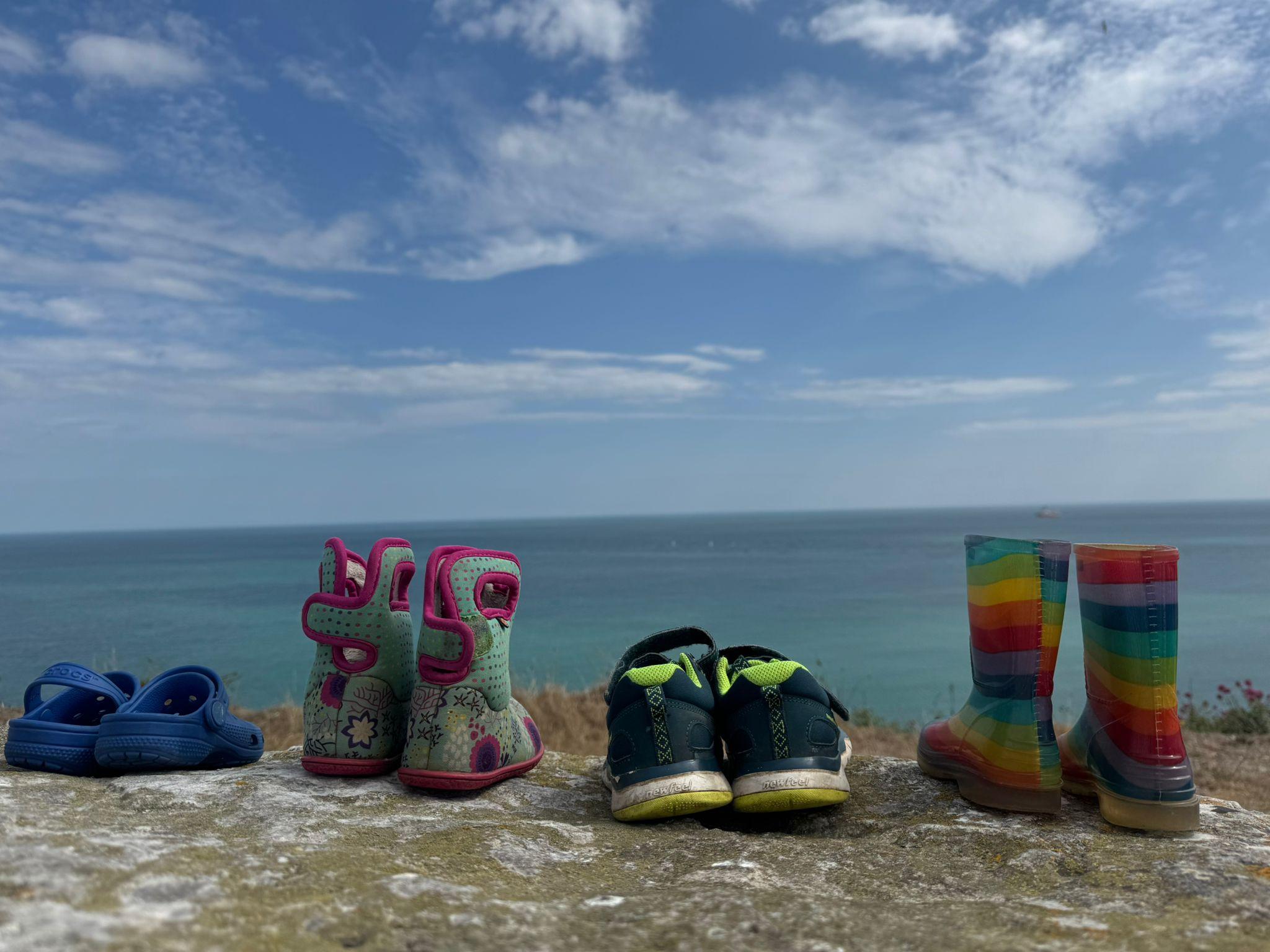Shoes on cliff top overlooking sea
