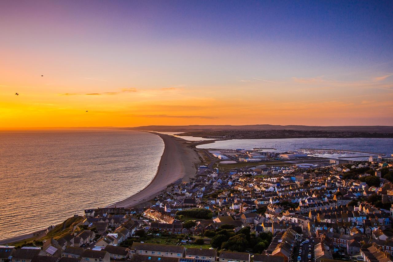 View from Portland looking out along the Chesil beach. In the foreground are houses.