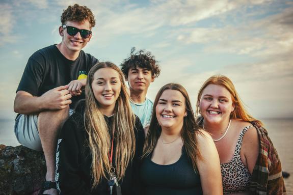 four young people smile at the camera